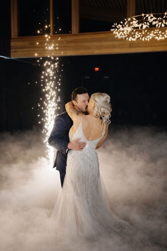 Primer baile con chispas frías iluminando a los novios