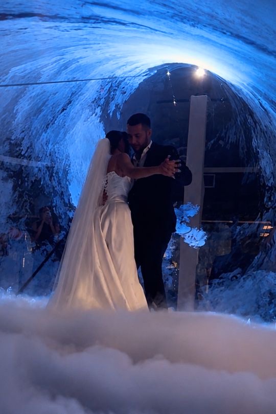 Los novios abrazados en el túnel de láser y humo pesado en Mas de la Sala