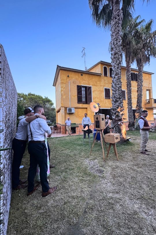 Montaje del fotomatón con fondo dorado en el jardín de Villa Golf, con la finca al fondo — boda en Sitges