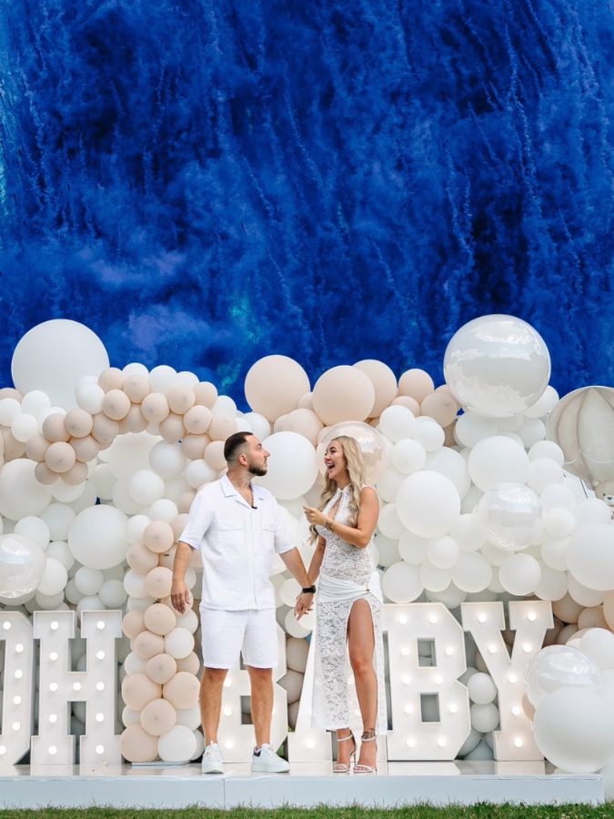 Humo aéreo azul en baby shower con globos blancos