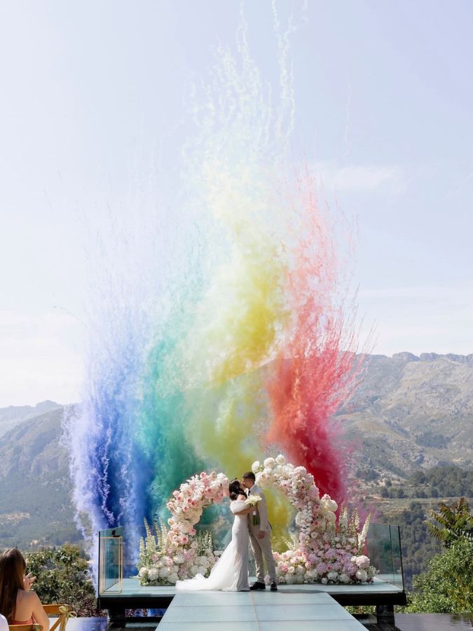 Humo rosa y lila en boda con arreglos florales