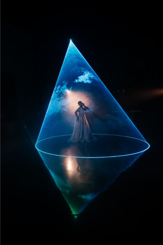 Cono de luz láser azul formando diamante con reflejo en suelo — efecto láser boda