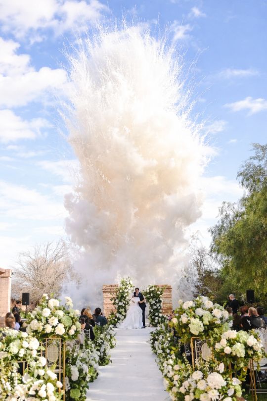 Ceremonia de boda con humo blanco entre flores