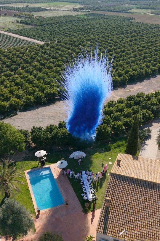 Gender reveal con humo azul en una finca con piscina